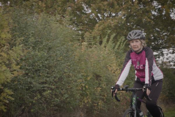 woman with hearing loss cycling down country lane