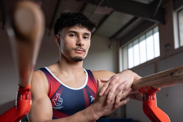 Gymnast Jake Jarman poses by the parallel bars